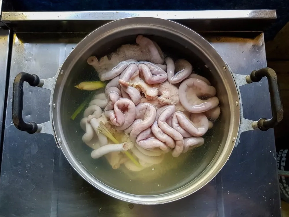 Chần sơ lòng non qua nước sôi với gừng để khử mùi và tạo độ giòn