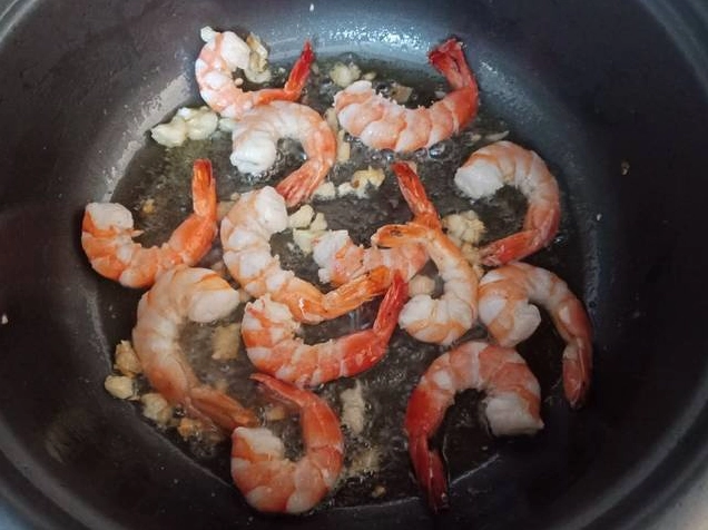 Cho mì vào chảo xào đều cùng rau củ và tôm mực
