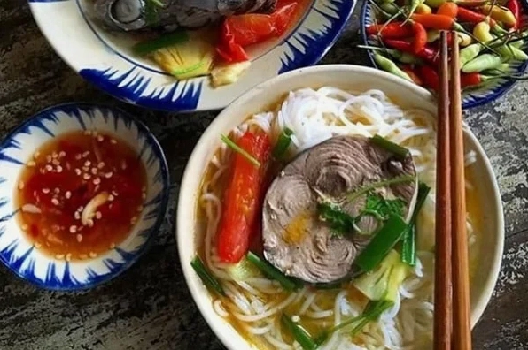 Công đoạn sơ chế các nguyên liệu nấu bún cá ngừ bao gồm cá ngừ thơm cà chua và rau thơm
