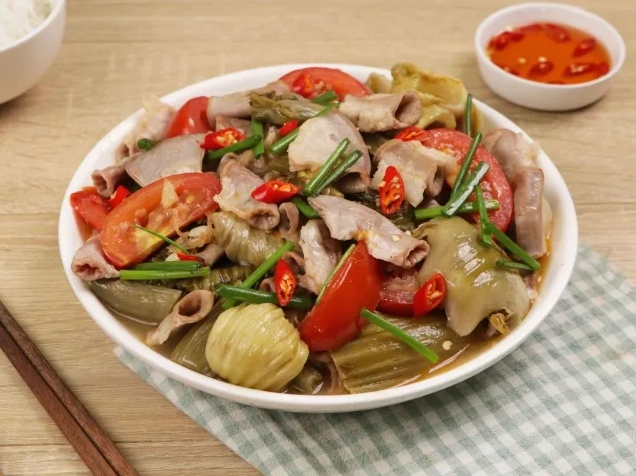 Công đoạn xào dưa chua và lòng lợn trên chảo