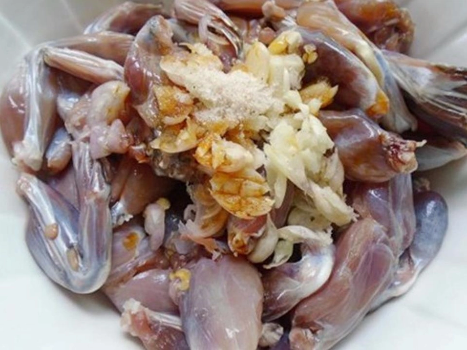 Công đoạn xào thịt ếch cùng sả ớt trên chảo nóng hổi tỏa mùi thơm nức mũi