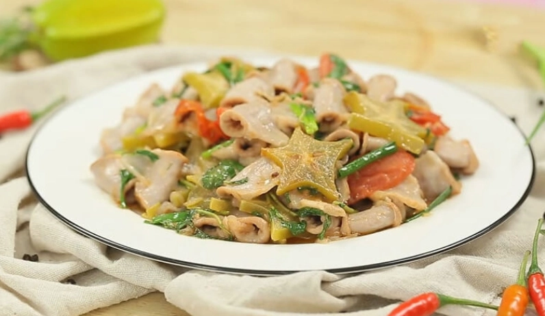 Đảo đều thịt dê cùng khế chua trên chảo nóng hổi