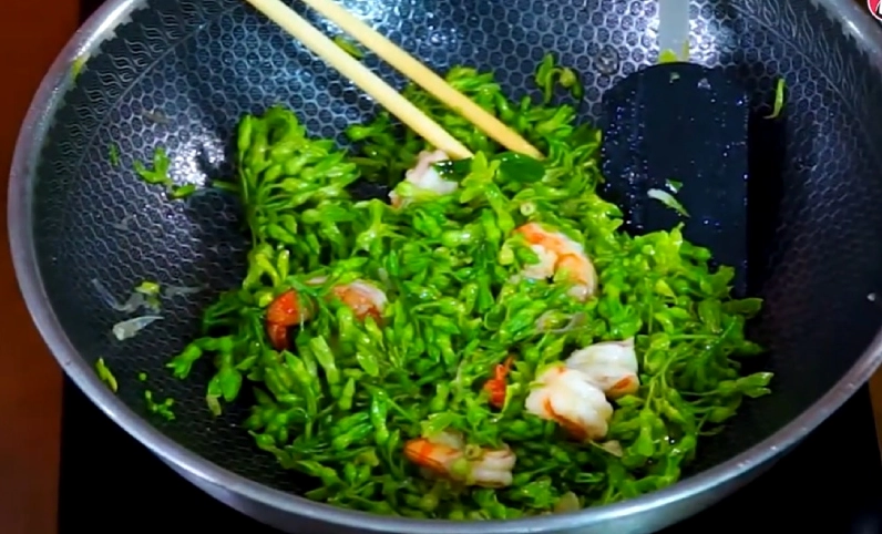 Hình ảnh đang xào hoa thiên lý với tôm trên chảo