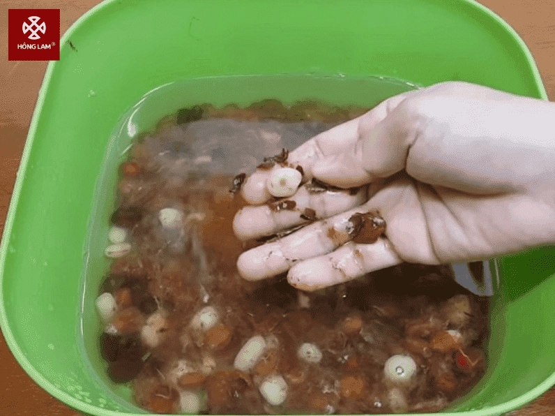 Hỗn hợp nước cốt me đang được đun trên bếp cùng với dứa băm nhỏ và gừng giã nát