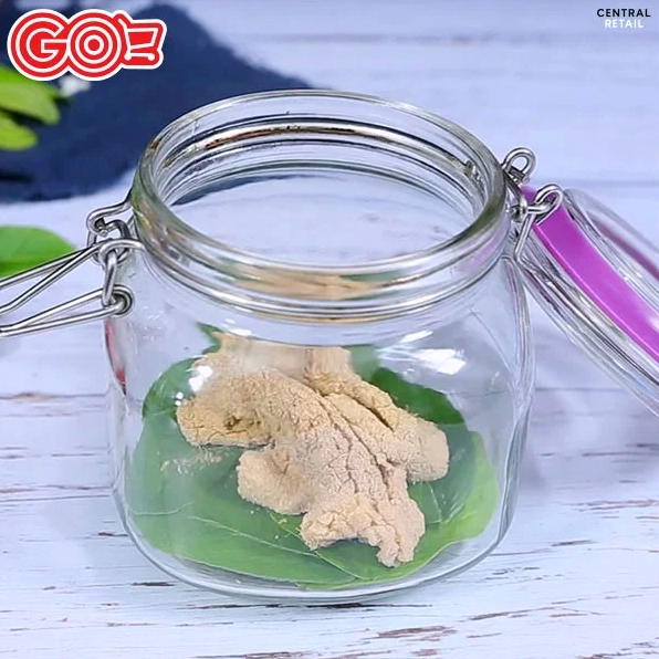 Hũ thủy tinh chứa thịt chua Thanh Hóa đang được ủ cùng lá ổi, lá sung, lá đinh lăng.