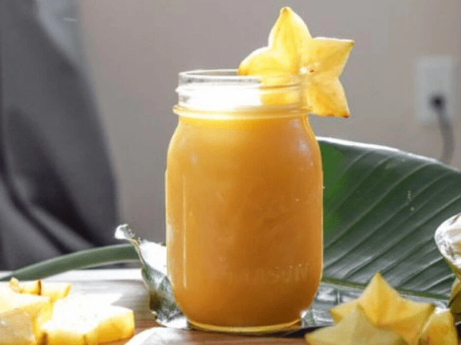 Ly nước ép khế vàng óng ả được trang trí tinh tế sẵn sàng để thưởng thức