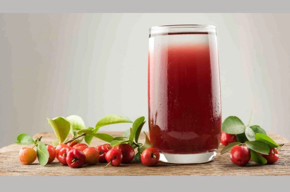 Ly nước ép sơ ri màu đỏ tươi tắn hấp dẫn bên cạnh rổ sơ ri chín mọng