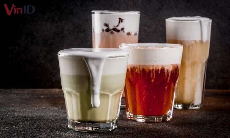 Ly trà sữa macchiato với lớp nền trà đậm màu và kem trắng phía trên