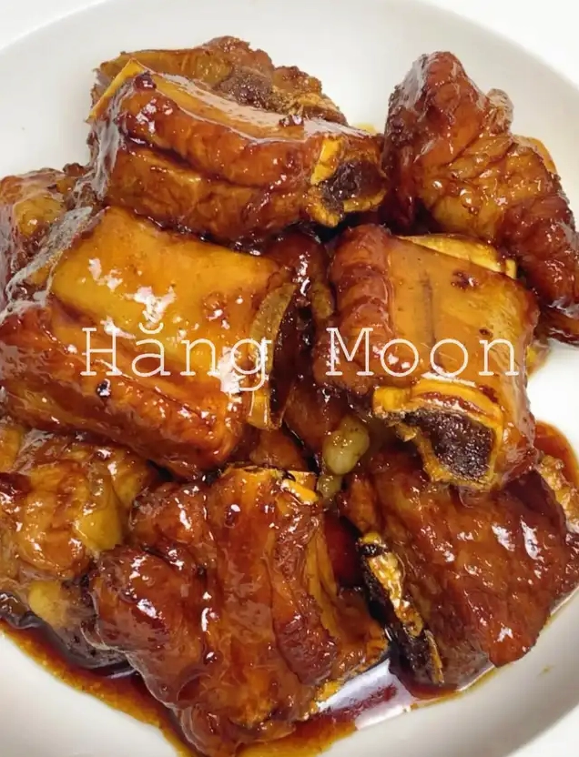 Món sườn non rim mặn ngọt đậm đà màu nâu bóng hấp dẫn được trình bày trong tô trắng sẵn sàng để thưởng thức