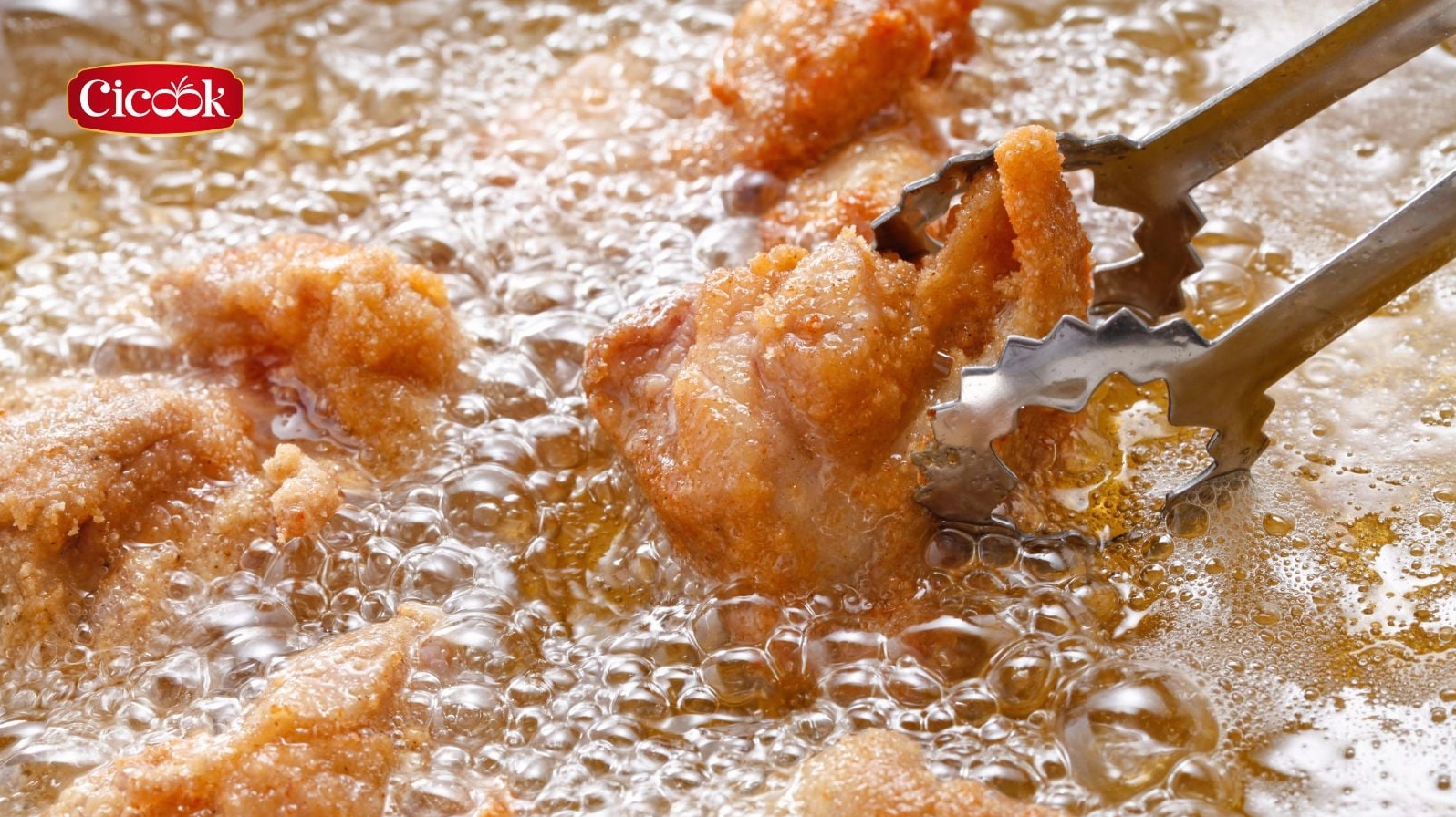 Những miếng gà rán đang được chiên ngập trong chảo dầu sôi