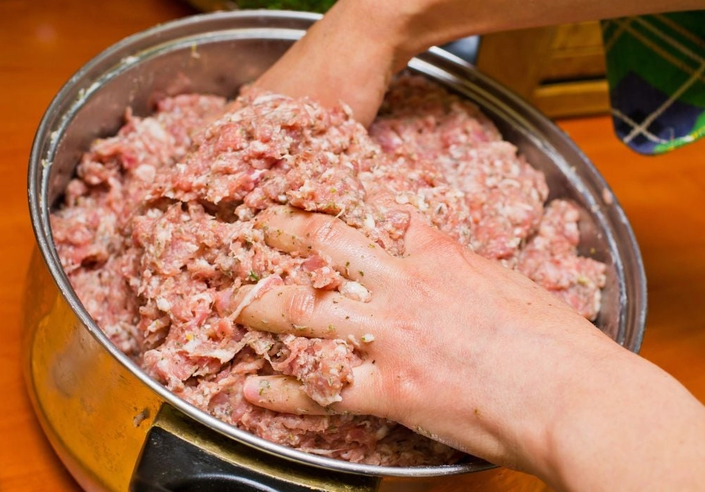 Quá trình trộn đều hỗn hợp thịt xay và giò sống cùng các loại gia vị