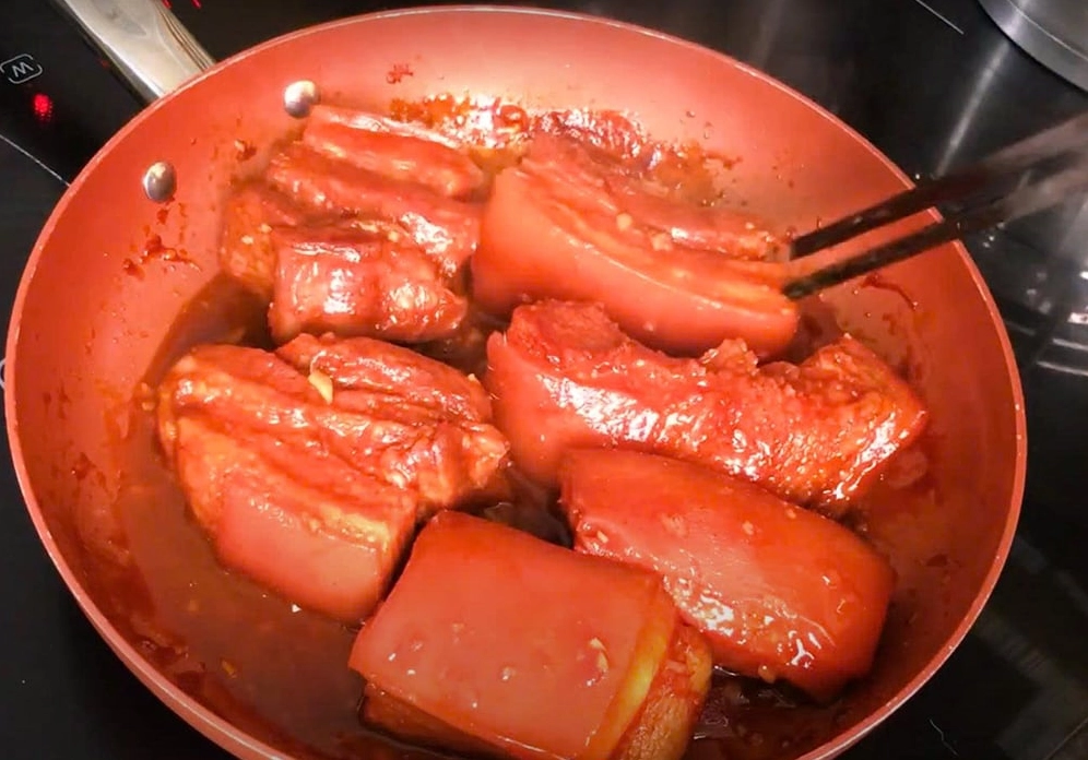 Thịt đang được rim liu riu trong chảo cùng phần nước sốt ướp đặc kẹo lại