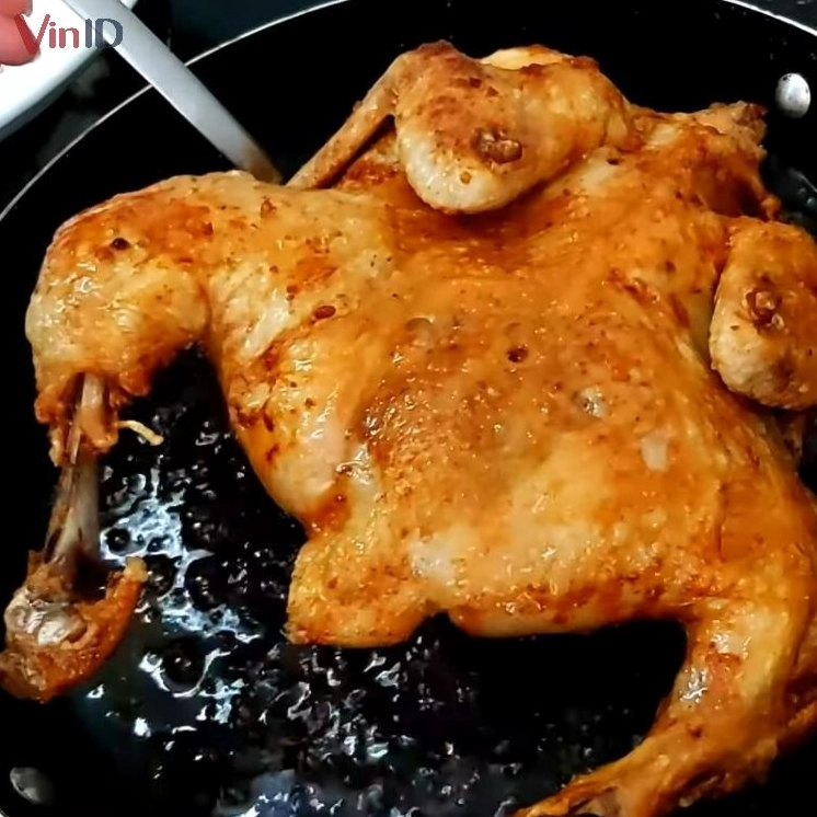 Thịt gà đang được chiên vàng giòn trong chảo ngập dầu
