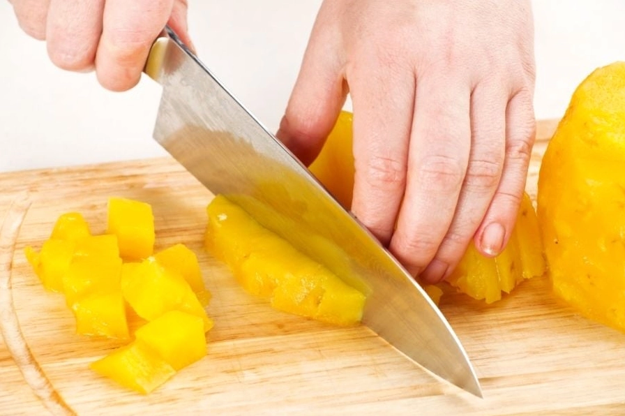 Tiến hành cắt quả dứa tươi thành những miếng nhỏ vừa ăn