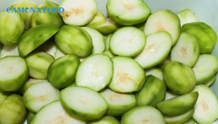 Tiến hành gọt vỏ và thái lát mỏng hoặc bào sợi những trái cóc xanh