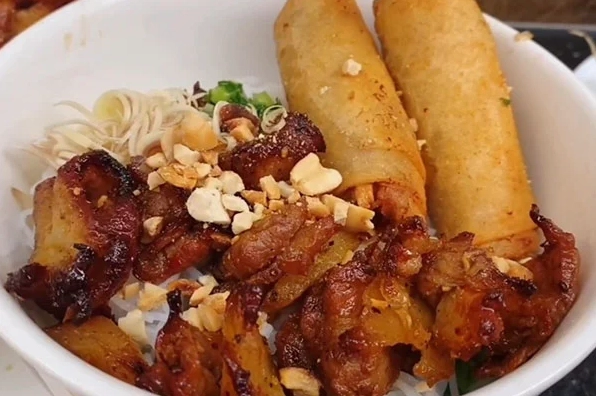 Tô bún thịt nướng đầy đủ màu sắc hấp dẫn với thịt nướng vàng ươm và rau sống tươi xanh