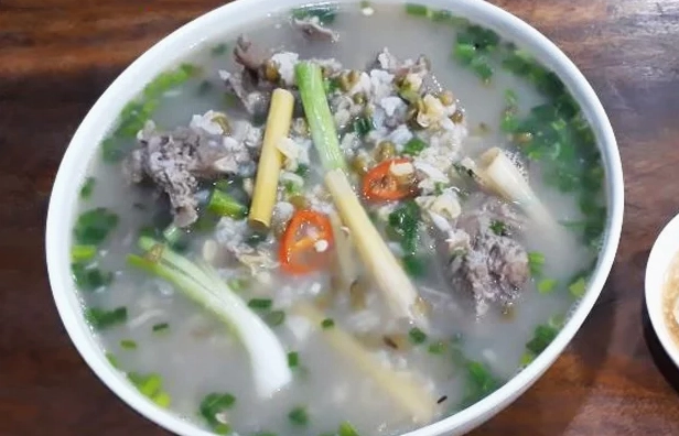 Tô cháo thịt dê nóng hổi rắc thêm chút tiêu và hành ngò