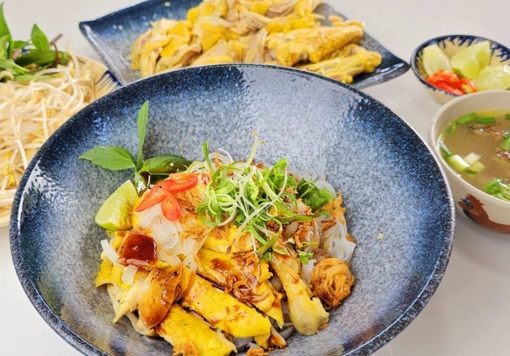 Tô phở trộn gà hoàn chỉnh với đầy đủ thịt xé phay rau thơm hành phi lạc rang và nước xốt đậm đà
