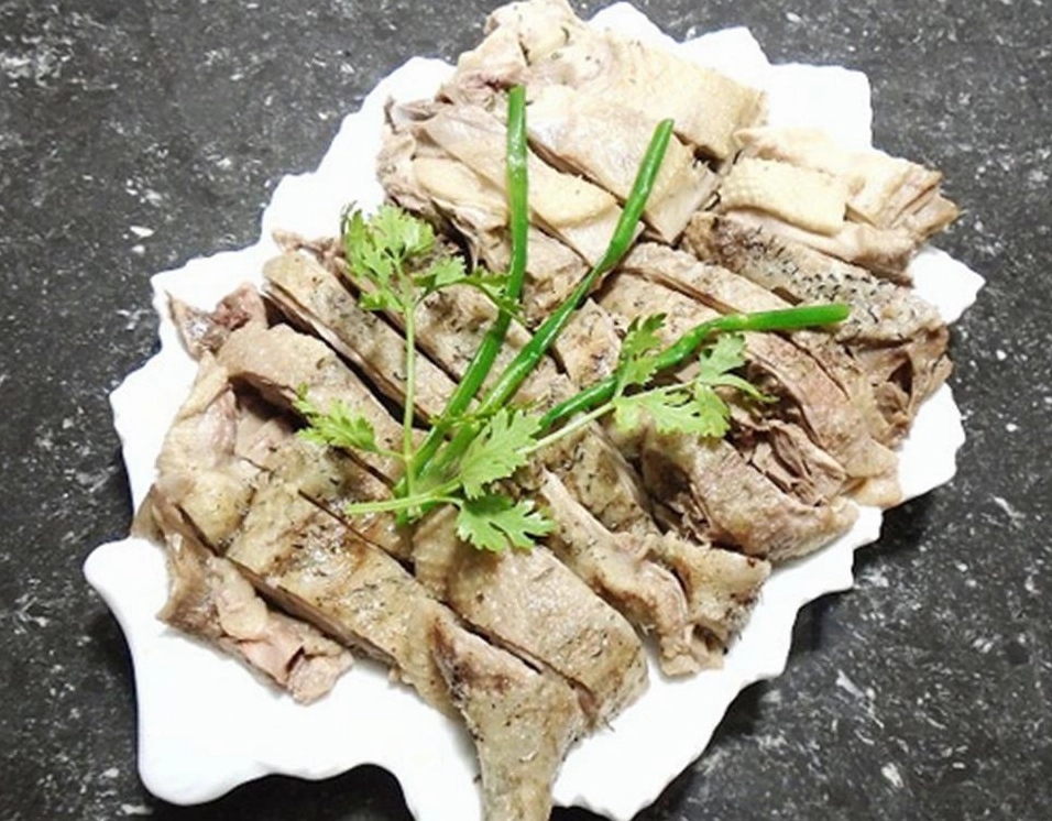 Trình bày tô bún măng vịt chan nước lèo nóng hổi lên trên bún và thịt