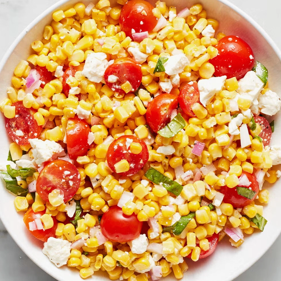 Trộn nhẹ nhàng các nguyên liệu salad ngô trong một chiếc tô lớn