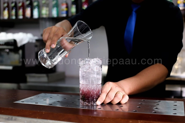 Từ từ rót đầy ly bằng nước soda có ga lên trên lớp đá viên